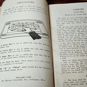 May include: A vintage Carroms game instruction booklet with a black and white illustration of a game board and a hand holding a ring. The text on the page explains the different types of shots in the game, including direct, carom, and bank shots. The booklet is copyrighted 1936 by Carrom Industries, Inc. in Ludington, Michigan.