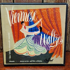 May include: Vintage album cover featuring a couple dancing the Viennese Waltz. The artwork depicts a man in a white suit and a woman in a purple dress, set against an orange curtain backdrop. The album title is "Viennese Waltzes" by Frank De Vol and his orchestra.