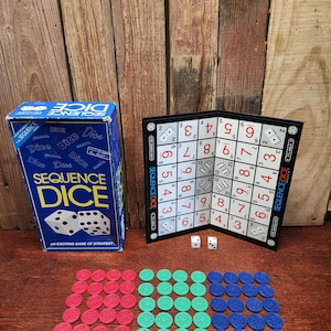 May include: A Sequence Dice game set. The image shows a blue box with the game title, a game board, dice, and red, green, and blue game tokens. The game board is black and white with numbers.