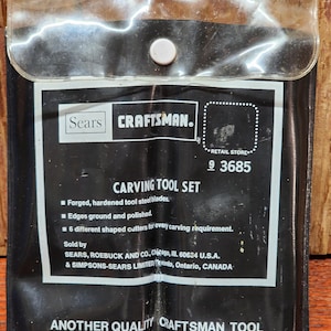 May include: A black Craftsman carving tool set in a clear plastic pouch. The set includes forged, hardened steel blades and six different shaped cutters. The text on the package reads "Another Quality Craftsman Tool."