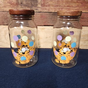 Two 1978 Juggling Garfield Anchor Hocking Glass Treat Cookie Jars with Wood Lid