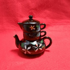 May include: A set of three ceramic mugs with a speckled, matte finish. The mugs are in shades of cream, light gray, and dark gray. Each mug has a simple, minimalist design, perfect for coffee or tea.
