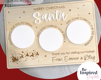 May include: A wooden Christmas serving board with the words "Merry Christmas Santa" and three circular cutouts. The board includes text for drinks, snacks, and carrots for the reindeer. The board is personalized with a family name.