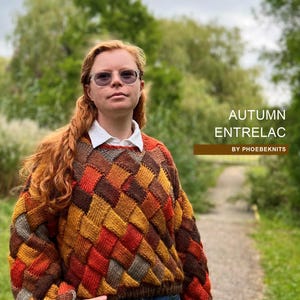 Può includere: Una persona indossa un maglione lavorato a mano con un motivo entrelac dai colori autunnali. Il maglione presenta un motivo geometrico nei toni del marrone, arancione e giallo. Il testo "AUTUMN ENTRELAC" è visibile.