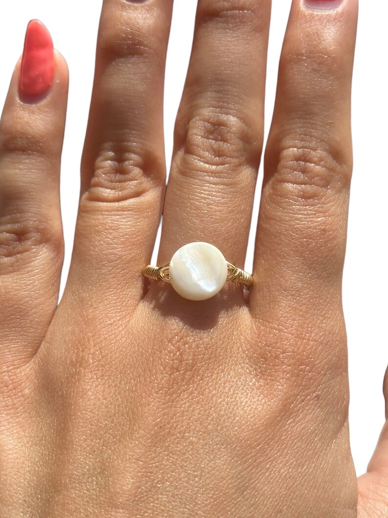 May include: A gold wire ring with a white mother of pearl stone.