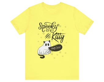 May include: A yellow t-shirt featuring a cartoon ghost cat with the text "Spooky Kitty" and a speech bubble that says "meow". The design includes stars and claw marks, perfect for Halloween.
