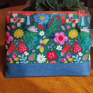 Bolso/muñequera con forma de hongo en rojo con colores primaverales. 25 x 18 cm con fondo de mezclilla reciclada de 5 cm.
