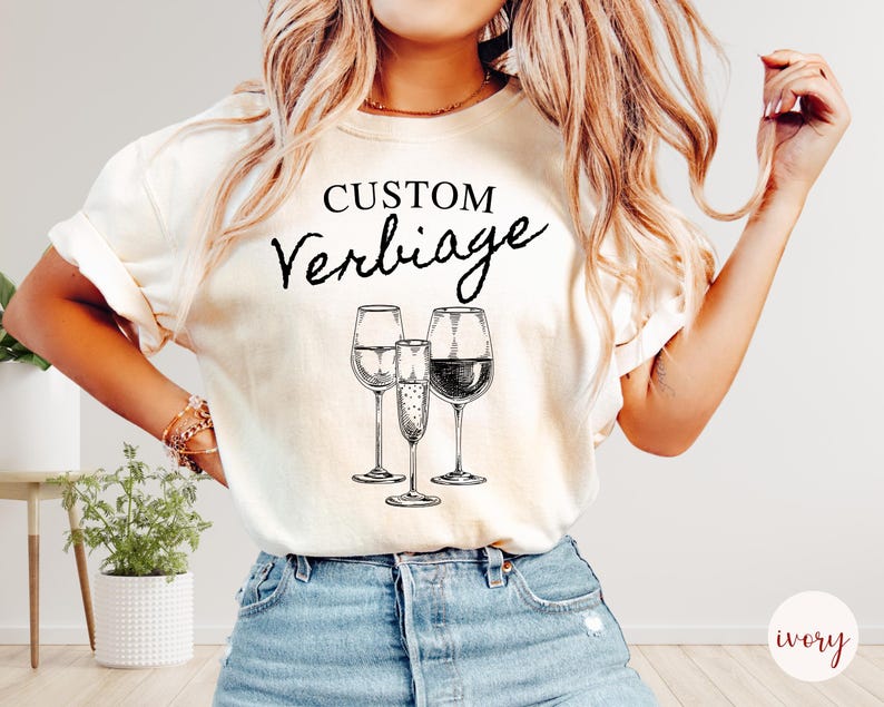 May include: A white t-shirt with the text "CUSTOM Verbiage" and a drawing of three glasses of wine.