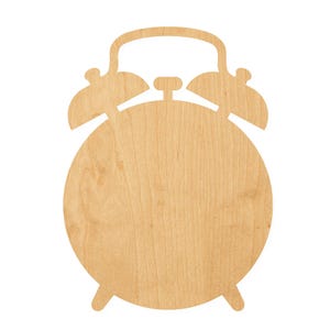 May include: A flat, light-colored wooden cutout shaped like a classic twin-bell alarm clock. The object features a circular face, two bell-shaped domes at the top, a central winding knob, a handle arching over the top, and two small feet at the base.