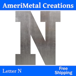 May include: A silver metal letter N with a brushed finish. The letter is large and has a simple, modern design.