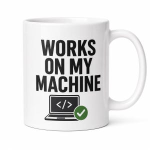 May include: White ceramic mug with the text "WORKS ON MY MACHINE" in black, along with a laptop graphic and a green checkmark. The mug has a curved handle and is designed for hot beverages.