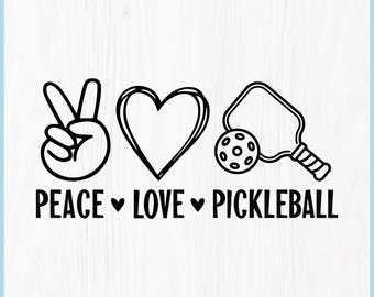 May include: Black and white digital download graphic with the words "Peace Love Pickleball". The design includes a peace sign, a heart, and a pickleball paddle and ball. The words "Digital Download" are at the top.