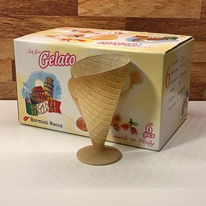 May include: A set of six gelato cone-shaped serving dishes. The box features the text "Set for Gelato" and "Vacanze Italiane" with an image of the Leaning Tower of Pisa. The cones are made in Italy.