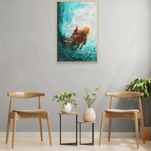 K&ouml;nnte beinhalten: Ein gerahmter Kunstdruck zeigt eine Figur im Wasser, mit ausgestreckter Hand. Das Kunstwerk verwendet T&uuml;rkis-, Braun- und Wei&szlig;t&ouml;ne, wodurch Tiefe und Bewegung entstehen. Der Rahmen ist hellbraun.