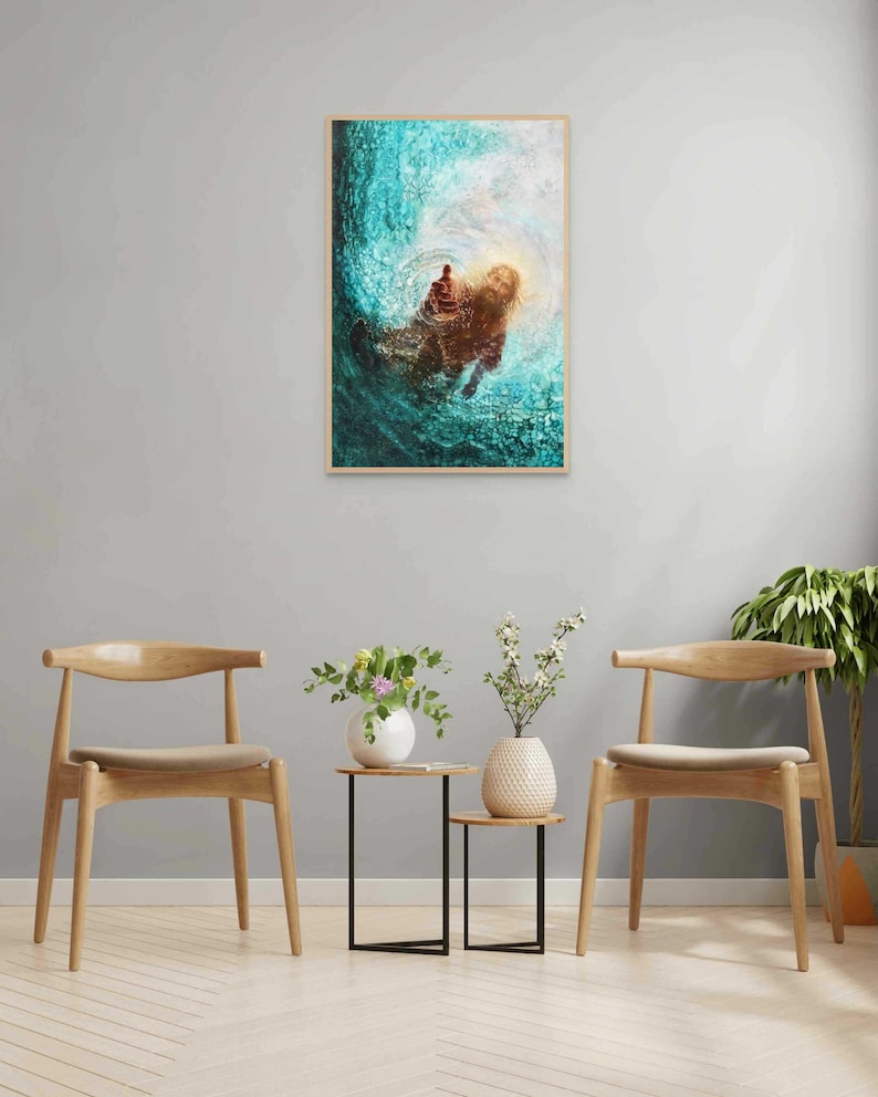 K&ouml;nnte beinhalten: Ein gerahmter Kunstdruck zeigt eine Figur im Wasser, mit ausgestreckter Hand. Das Kunstwerk verwendet T&uuml;rkis-, Braun- und Wei&szlig;t&ouml;ne, wodurch Tiefe und Bewegung entstehen. Der Rahmen ist hellbraun.