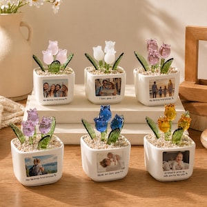 May include: Six small, white ceramic pots, each with a different colored glass tulip arrangement. Each pot has a small photo and a quote. The tulips are pink, white, blue, and yellow. The quotes include "I love you" and "my lifelong best friend."