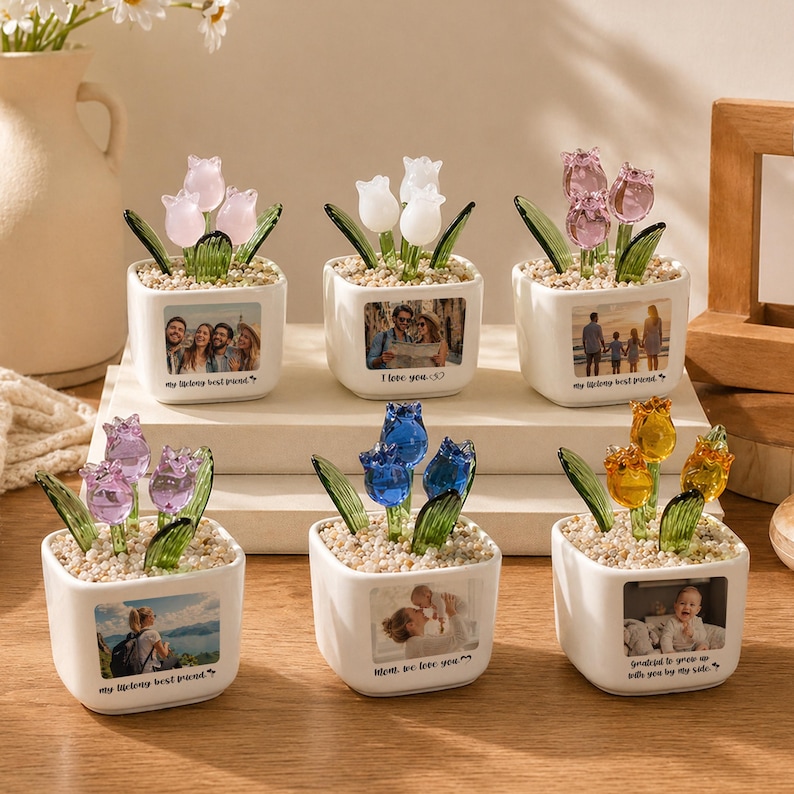 May include: Six small, white ceramic pots, each with a different colored glass tulip arrangement. Each pot has a small photo and a quote. The tulips are pink, white, blue, and yellow. The quotes include "I love you" and "my lifelong best friend."