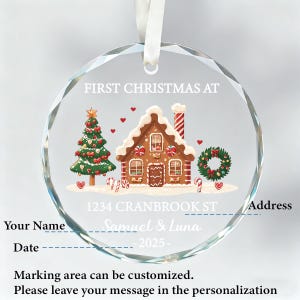 K&ouml;nnte beinhalten: Ein klarer, runder Weihnachtsschmuck mit einem Lebkuchenhaus, Weihnachtsbaum und Kranz-Design. Der Schmuck enth&auml;lt den Text "FIRST CHRISTMAS AT" und Platz f&uuml;r Personalisierung. Ein wei&szlig;es Band ist zum Aufh&auml;ngen befestigt.