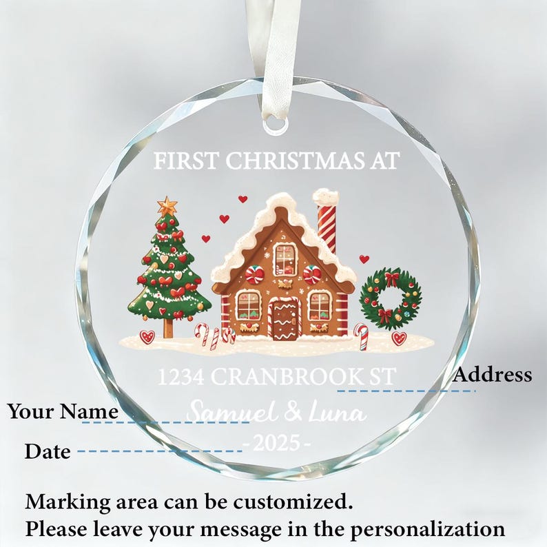 K&ouml;nnte beinhalten: Ein klarer, runder Weihnachtsschmuck mit einem Lebkuchenhaus, Weihnachtsbaum und Kranz-Design. Der Schmuck enth&auml;lt den Text "FIRST CHRISTMAS AT" und Platz f&uuml;r Personalisierung. Ein wei&szlig;es Band ist zum Aufh&auml;ngen befestigt.
