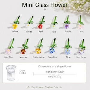 May include: A collection of twelve miniature glass flowers in various colours including yellow, white, red, pale, purple, pink, light pink, amber, golden yellow, deep blue, blue, and light purple, each with a green stem and leaves.