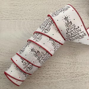 May include: White Christmas ribbon with a red stitched edge. The ribbon features the words "Joy, peace, tis the season, merry Christmas" in black script, along with a Christmas tree and star design. Green and red dots are scattered across the ribbon.