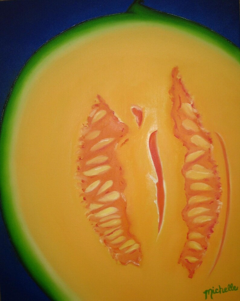 May include: A close-up of a halved cantaloupe melon with a bright orange flesh and a green rind. The melon has a distinct, symmetrical pattern of seeds in the center.