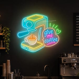 May include: A neon sign featuring a stylized espresso machine in bright blue and yellow light, accompanied by a speech bubble containing the text "give me coffee" in pink and blue, with a small green heart icon next to the text.
