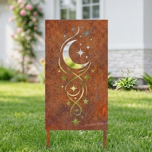 Puede incluir: Una estaca de jardín rectangular de metal marrón oxidado con un diseño de luna creciente y estrellas. El diseño está recortado del metal, creando un efecto decorativo. El texto "Enchantingspace" es visible en la parte superior e inferior de la estaca.