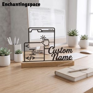 May include: A black laser-cut sign featuring a computer browser window icon with a cursor and code symbols, mounted on a rectangular wooden base. The sign includes the text Custom Name in a script font, displayed on a desk with office supplies.
