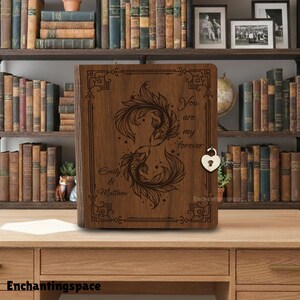 May include: A wooden keepsake box with a heart-shaped lock. The box features an engraved design of two koi fish and the words "You are my forever" and "Emily & Matthew". The box is brown and sits on a wooden desk.