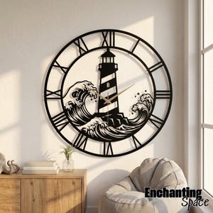 May include: A circular black metal wall clock featuring a lighthouse and crashing waves design. The clock face displays Roman numerals around the perimeter and includes thin gold-colored hour and minute hands. The text Enchanting Space is visible.