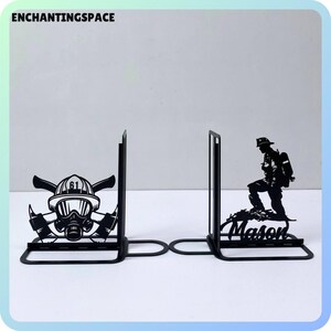 May include: Black metal bookends featuring a firefighter design. One bookend has a firefighter helmet with an axe and the number 61. The other bookend has a firefighter running with a hose and the name "Mason".