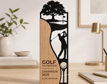 Könnte beinhalten: Eine vertikale Trophäe mit einer hellen Holzplatte auf der linken Seite und einem schwarzen Ausschnitt auf der rechten Seite. Der schwarze Teil zeigt einen Golfer, einen Baum und einen Golfball auf einem Tee. Text: GOLF TOURNAMENT CHAMPION 2026 ELITE DIVISION.
