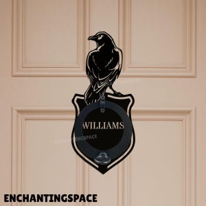 May include: A black metal door knocker with a raven design. The knocker is mounted on a shield-shaped plaque with a circular section bearing the name "WILLIAMS". The text "ENCHANTINGSPACE" is visible at the bottom of the image.