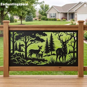 May include: A black metal decorative railing panel featuring a laser-cut forest scene with a large stag, a doe, and a fawn standing among pine trees and foliage. The panel is mounted within a wooden frame on a deck overlooking a grassy lawn.