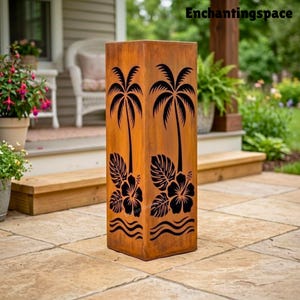 May include: A tall, rectangular, weathered metal outdoor decor piece. The design features black cut-out silhouettes of palm trees, hibiscus flowers, and waves. The piece is a warm, rusty brown color and stands on a stone patio.