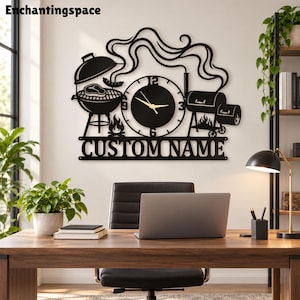 May include: A black metal wall clock featuring a barbecue theme with a kettle grill, a smoker, and stylized smoke trails. The clock face has gold hands and numbers, and a bottom panel displays the text CUSTOM NAME in bold capital letters.