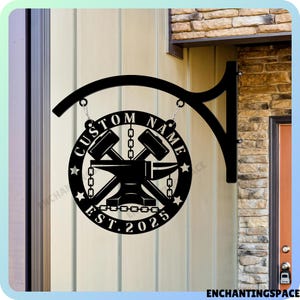 May include: Black metal sign with a custom name, an anvil, crossed hammers, and the text "Custom Name Est. 2025".