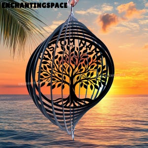 May include: A black metal wind spinner with a tree of life design. The tree is centered within a circular frame, surrounded by spiraling metal bands. The background shows a sunset over the ocean, with the text "ENCHANTINGSPACE".