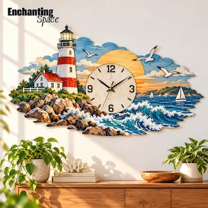 Könnte beinhalten: Eine Wanduhr mit einer Küstenszene, die einen rot-weißen Leuchtturm, eine gelbe Sonne, blaue Meereswellen und Möwen zeigt. Das Zifferblatt ist kreisförmig mit schwarzen Zahlen und Zeigern und in eine Illustration einer felsigen Küste integriert.
