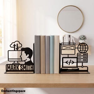 May include: A pair of black metal bookends featuring tech-themed cutouts. The left piece displays a computer monitor, a cloud icon, and the name MARK SMITH. The right piece features a globe, a server rack, and a laptop with code brackets.