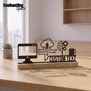 May include: A black metal desk sign featuring a computer monitor, a cloud icon with an upward arrow, a brain with gears, and a coffee mug silhouette. The sign includes the text CUSTOM TEXT and is mounted on a rectangular light wood base.