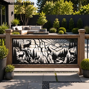 May include: A black metal decorative panel featuring a laser-cut mountain landscape with pine trees, a winding river, and four mountain goats standing on rocky cliffs. The design includes a sunburst pattern above the mountain peaks.
