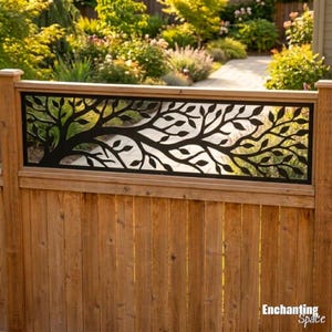 Peut inclure: Un panneau de clôture en bois avec un insert en métal noir présentant un motif de branche d'arbre découpé au laser. Le panneau rectangulaire affiche des feuilles et des branches complexes. Le texte Enchanting Space est visible en bas à droite.