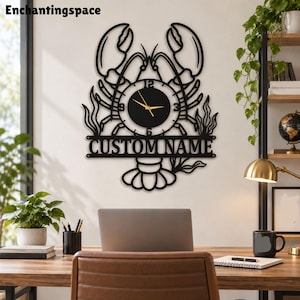 May include: A black metal wall clock shaped like a lobster with a circular clock face in the center featuring gold hands and numbers. Below the clock face is a horizontal bar with the text CUSTOM NAME in bold, capital, sans-serif letters.