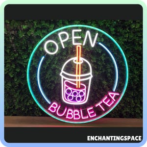 May include: A neon sign with a pink, blue, and green border. The sign says "OPEN BUBBLE TEA" with a neon image of a bubble tea cup with a straw in the center.