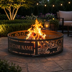 May include: A circular black metal fire pit ring featuring cut-out silhouettes of skunks and wildflowers. The side of the ring displays the text CUSTOM NAME in a bold serif font. A bright orange fire burns inside the metal structure.