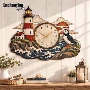 May include: A wall clock featuring a red and white lighthouse, a puffin, and a sunset scene. The clock face has black numbers and gold hands. The text Enchanting Space is visible in the upper left corner. The design includes rocky cliffs, ocean waves, and clouds.