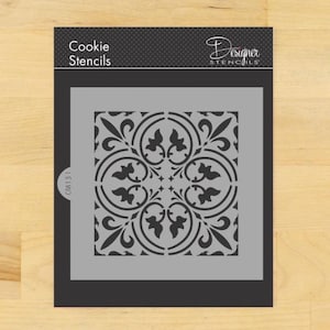May include: A black and gray cookie stencil with a square design featuring a repeating pattern of stylized leaves and swirls. The stencil is labeled "Cookie Stencils" and "Designer Stencils".