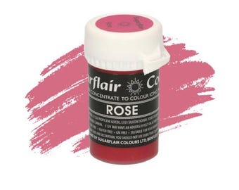 May include: A small, round plastic bottle of rose-colored food coloring concentrate. The bottle has a white lid and a black label with the words "Sugarflair" and "Rose" printed on it.